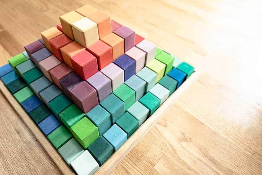 A pyramid block tower of all different colors of the rainbow.
