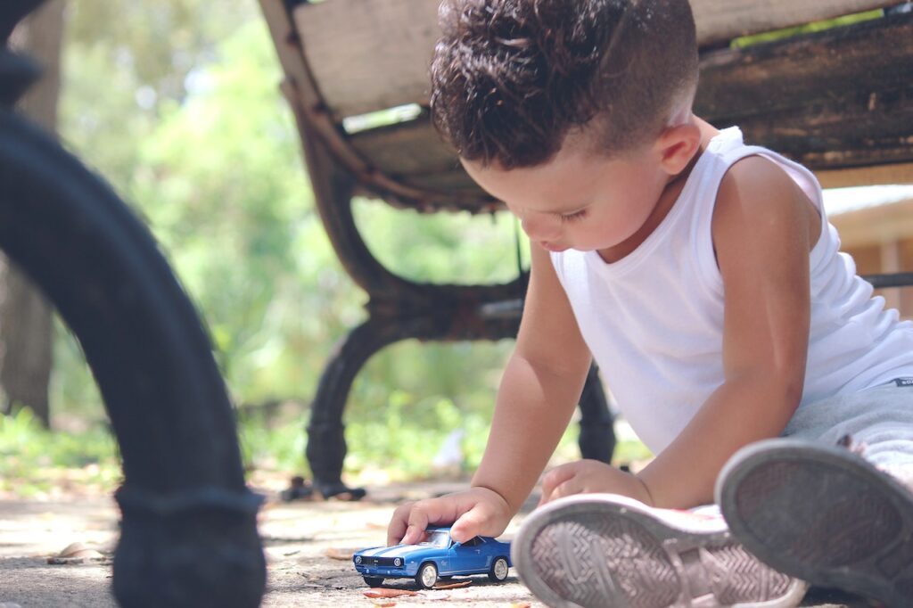 Early childhood education--boy playing with small blue car