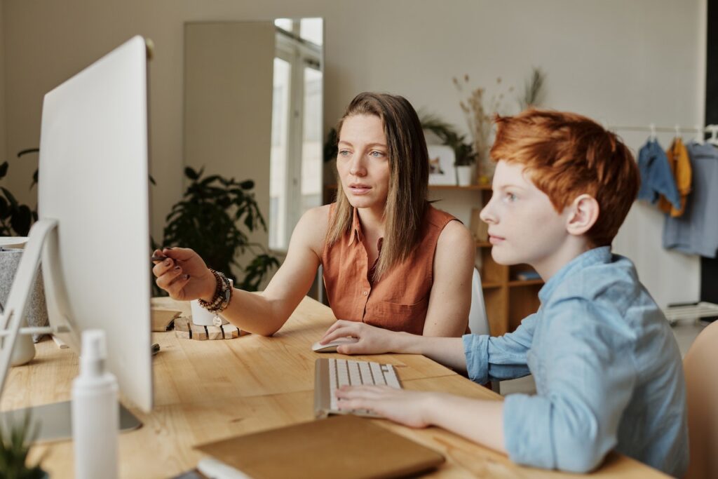 parent sitting next to computer with child supporting their project-based learning